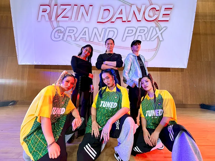 バックドロップの前でぽーすを取るダンサー